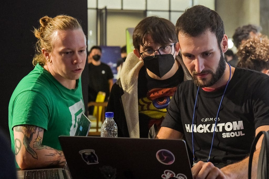 A photograph taken at the Hackatom event in Seoul 2022, showing Gjermund observing another participant coding.