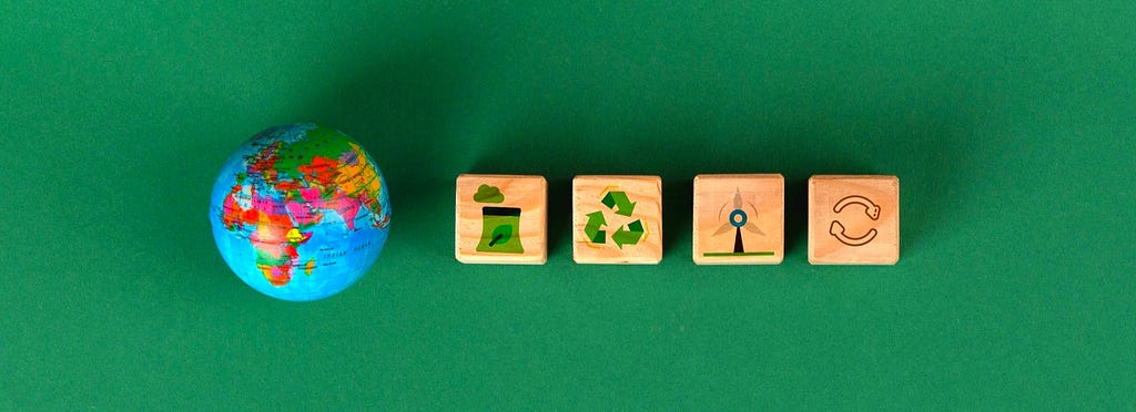 Symbols of sustainability etched on cubes alongside a mini globe
