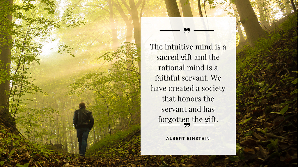 Man walking in woods with etherial sunlight shining through, and Albert Einstein’s quote about the intuitive mind is a sacred gift and the rational mind is a faithful servant.