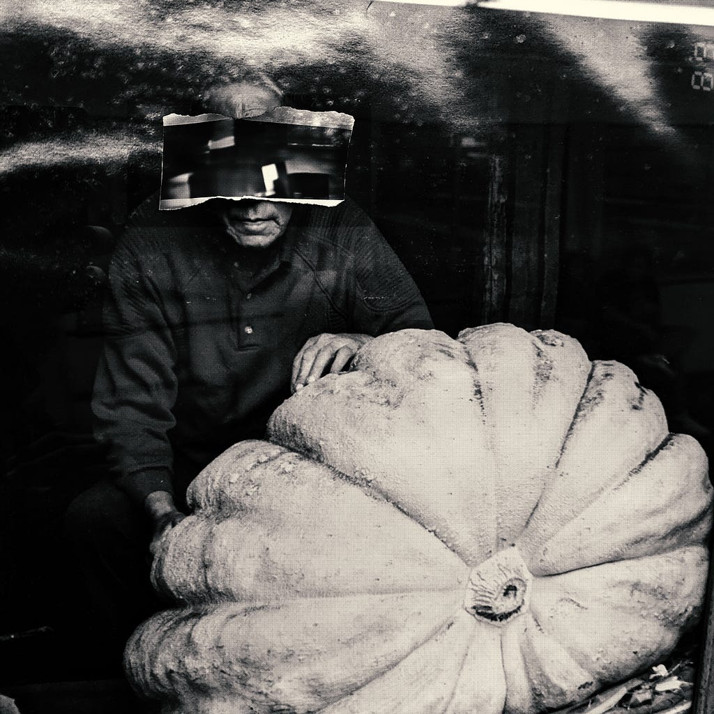 A man sits with his pumpkin.