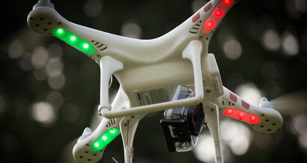 Photo of a small drone from under with red and green directional lights.
