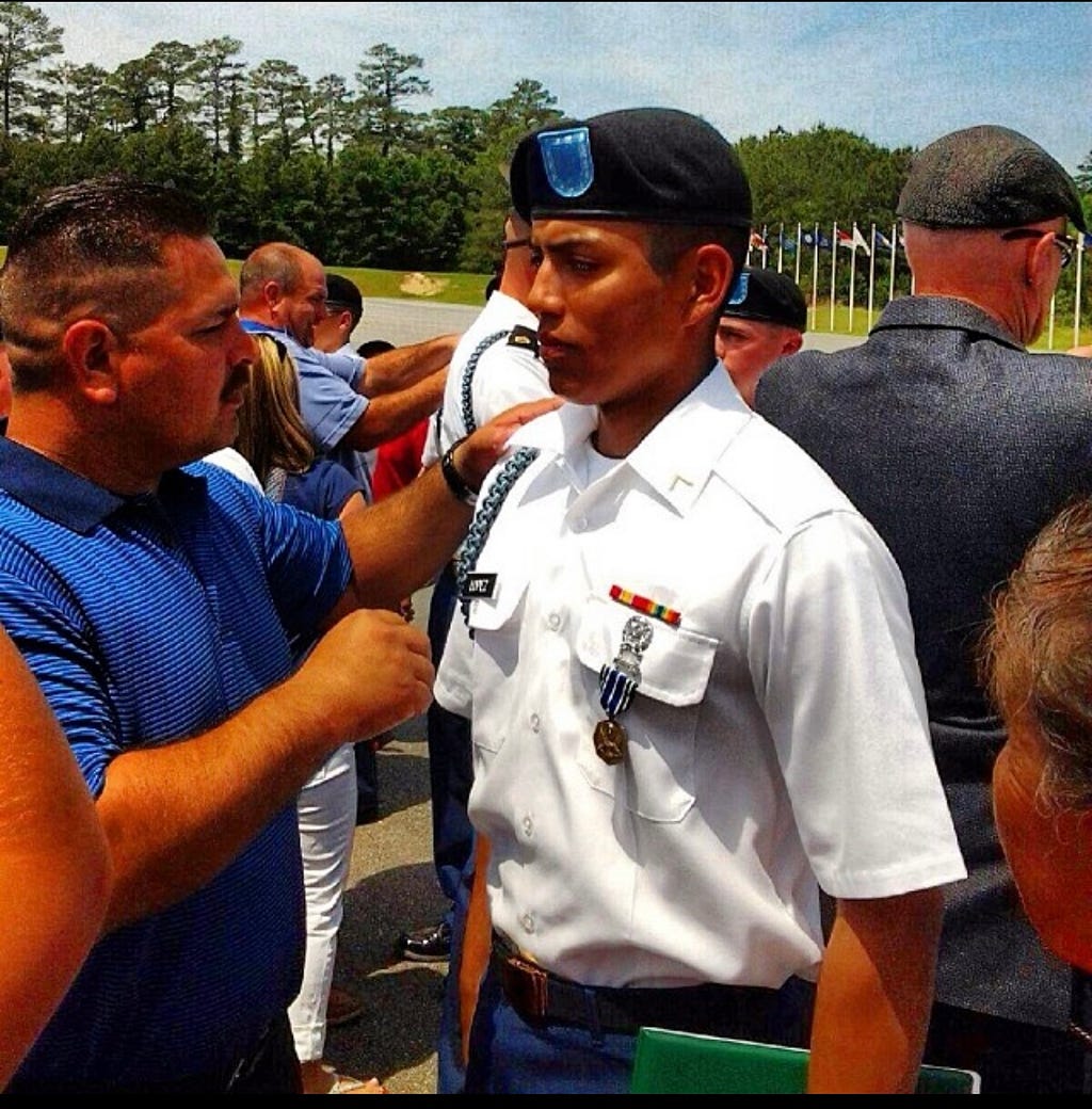 Mark Lopez receiving his Blue Cord pinned on by his dad. May 9th, 2014 Fort Benning, GA