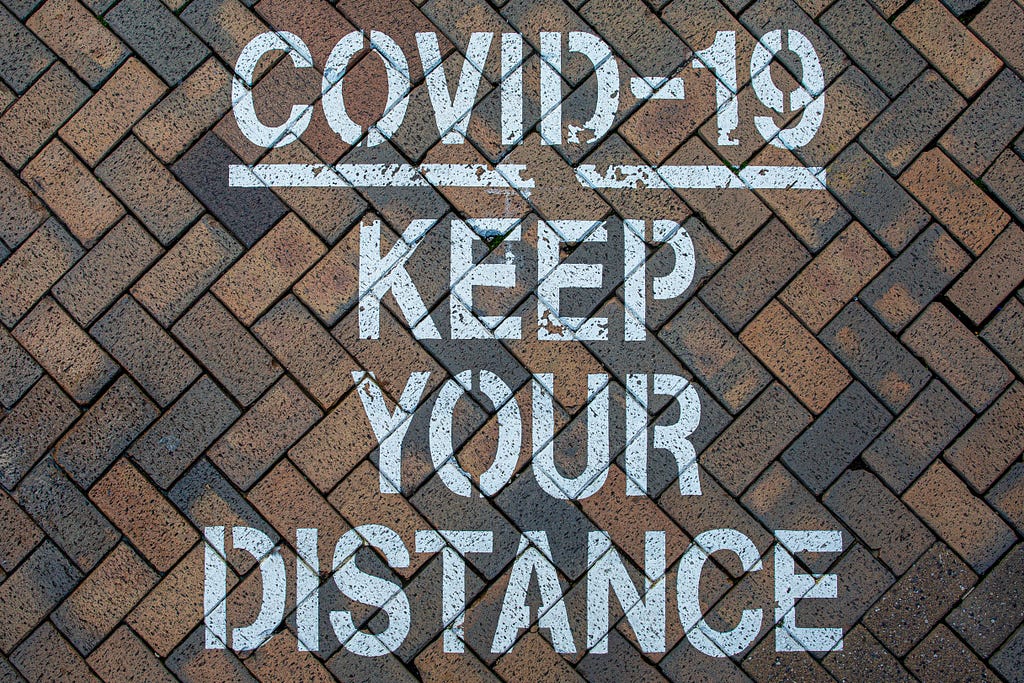 A sprayed warning of Coronavirus on the pavement.
