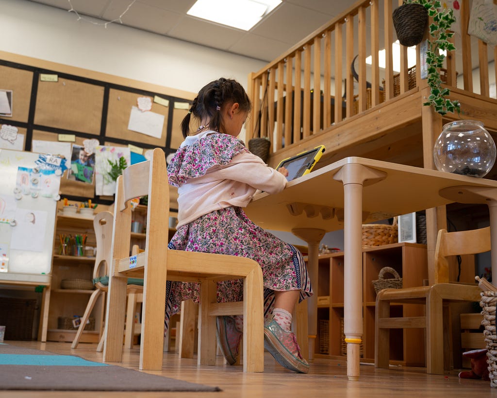 Young child learning in school on her tablet.