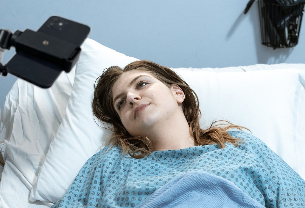 A woman lying in the bed, using AAC tool