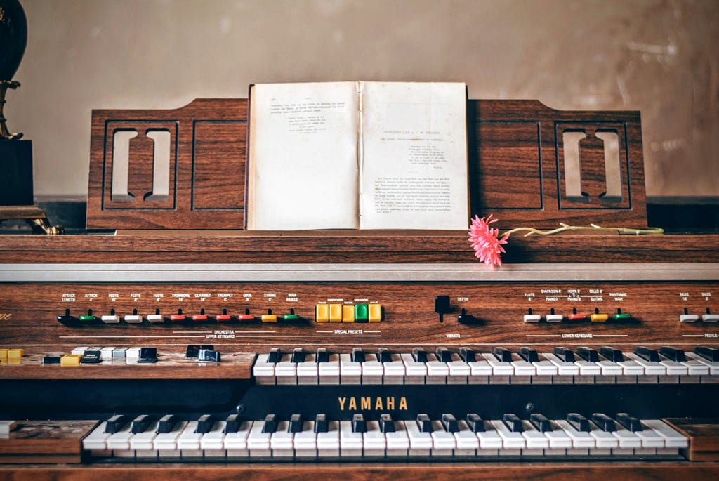 yamaha piano with a notebook and flower