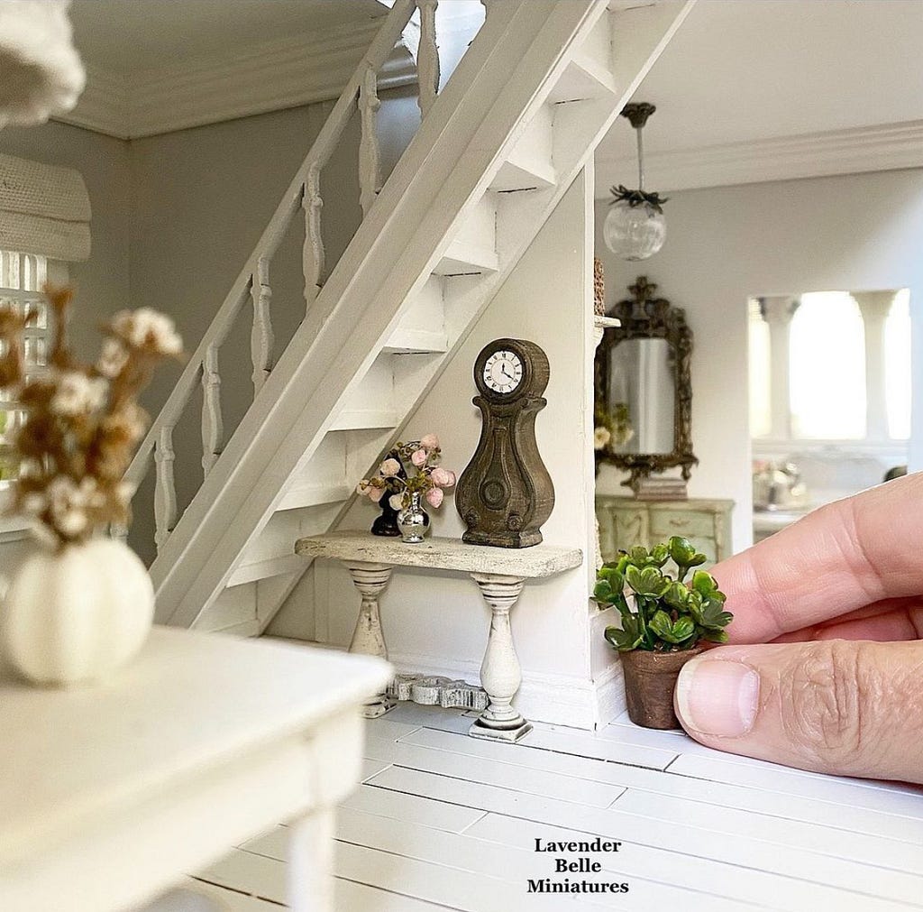 Hand carefully placing furniture in a dollhouse