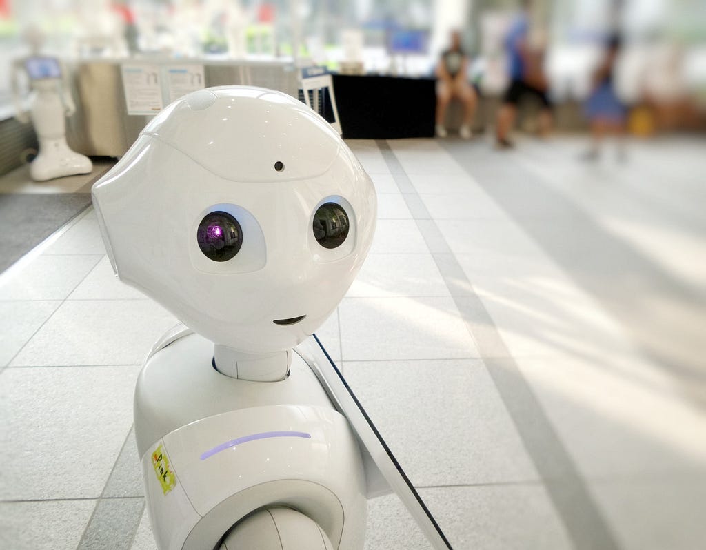 Robot made out of what looks like white plastic is looking at the reader