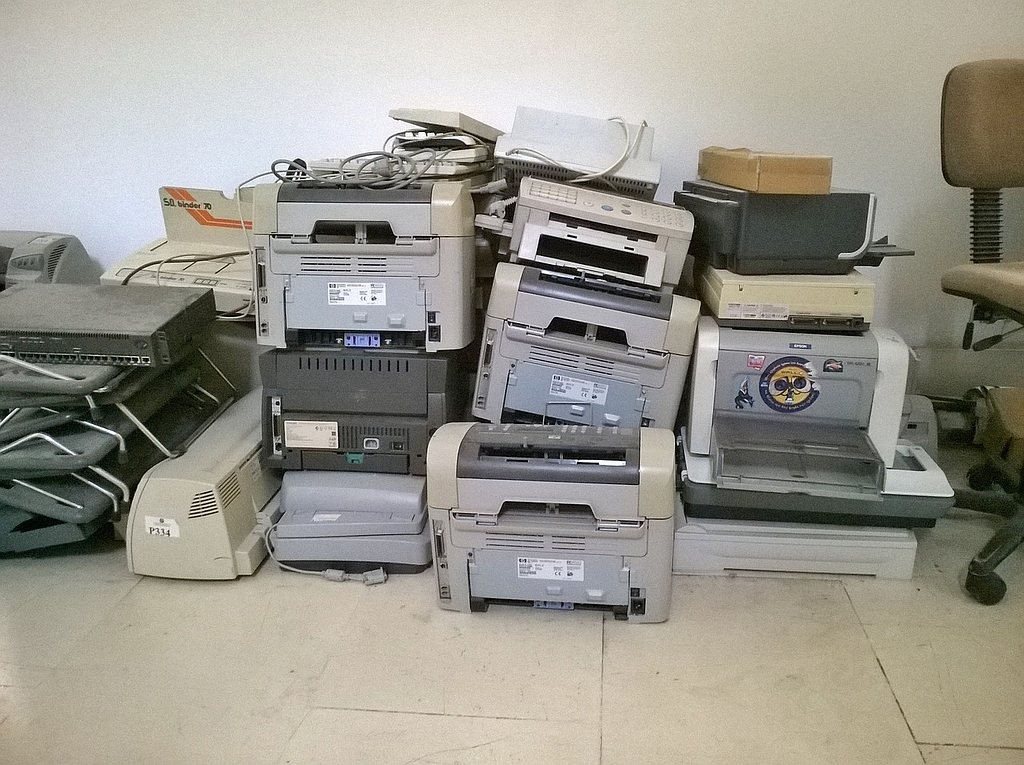 Several Office Printers Stacked on Top of Each Other After Falling into Disuse and Disrepair