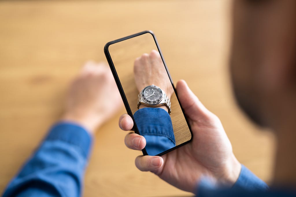 Man tries on wristwatch using AR on his phone