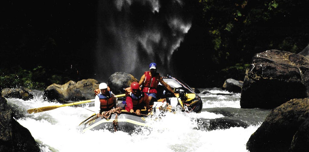 Guide and two clients in whitewater raft.