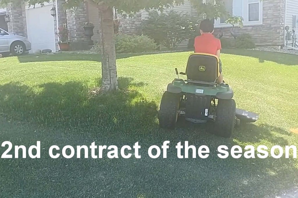 boy riding a riding lawn mower with caption 2nd contract of the season