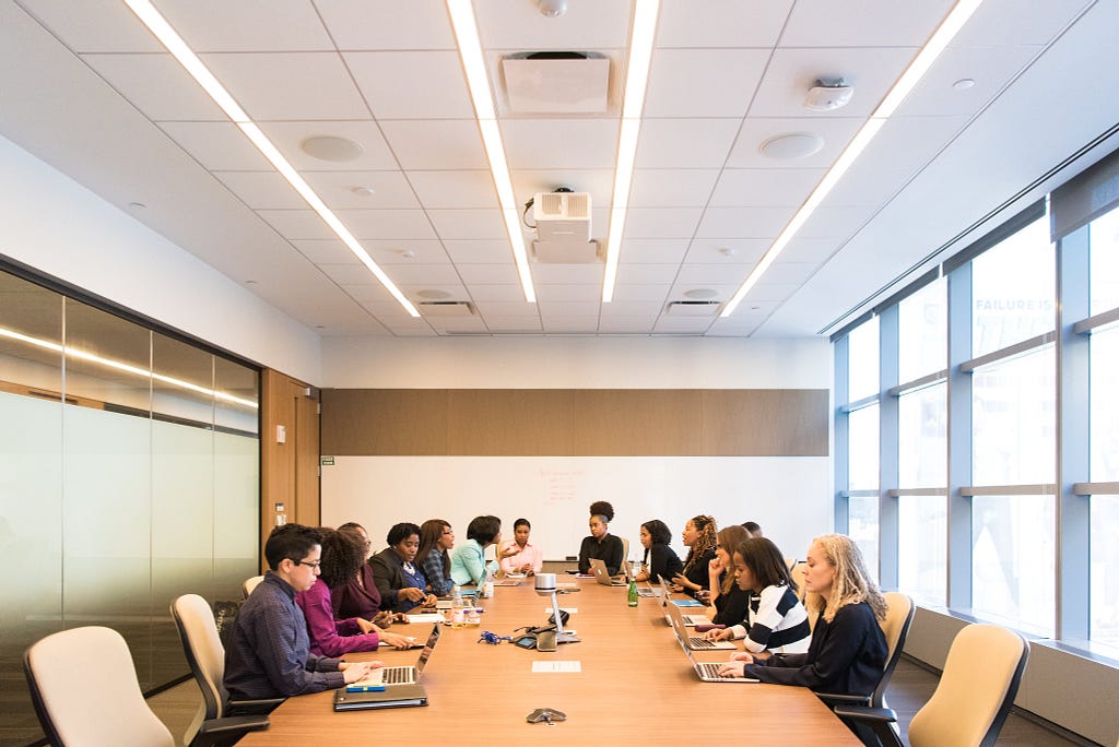 A photo of stakeholders in a large meeting room.