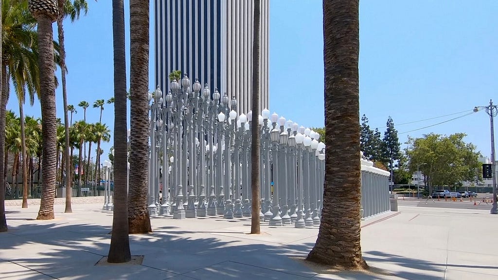 Urban Light sculpture at Los Angeles County Museum of Art with 5900 Wilshire building in the background at 10 minutes drive to the east of Beverly Hills Aesthetic Dentistry