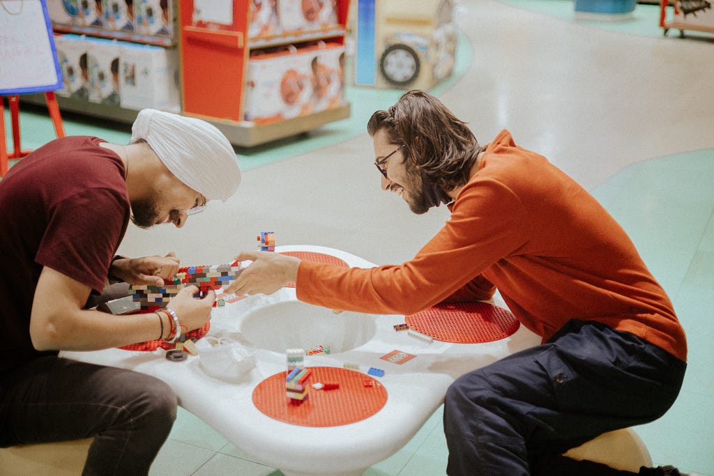 Two men playing with LEGO together