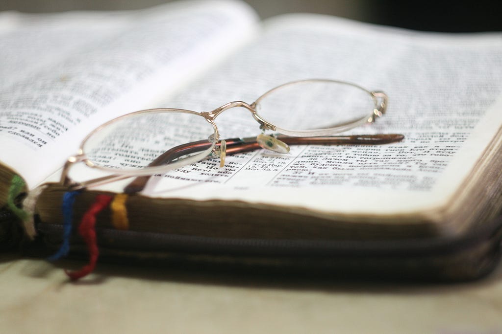 open bible with glasses on top