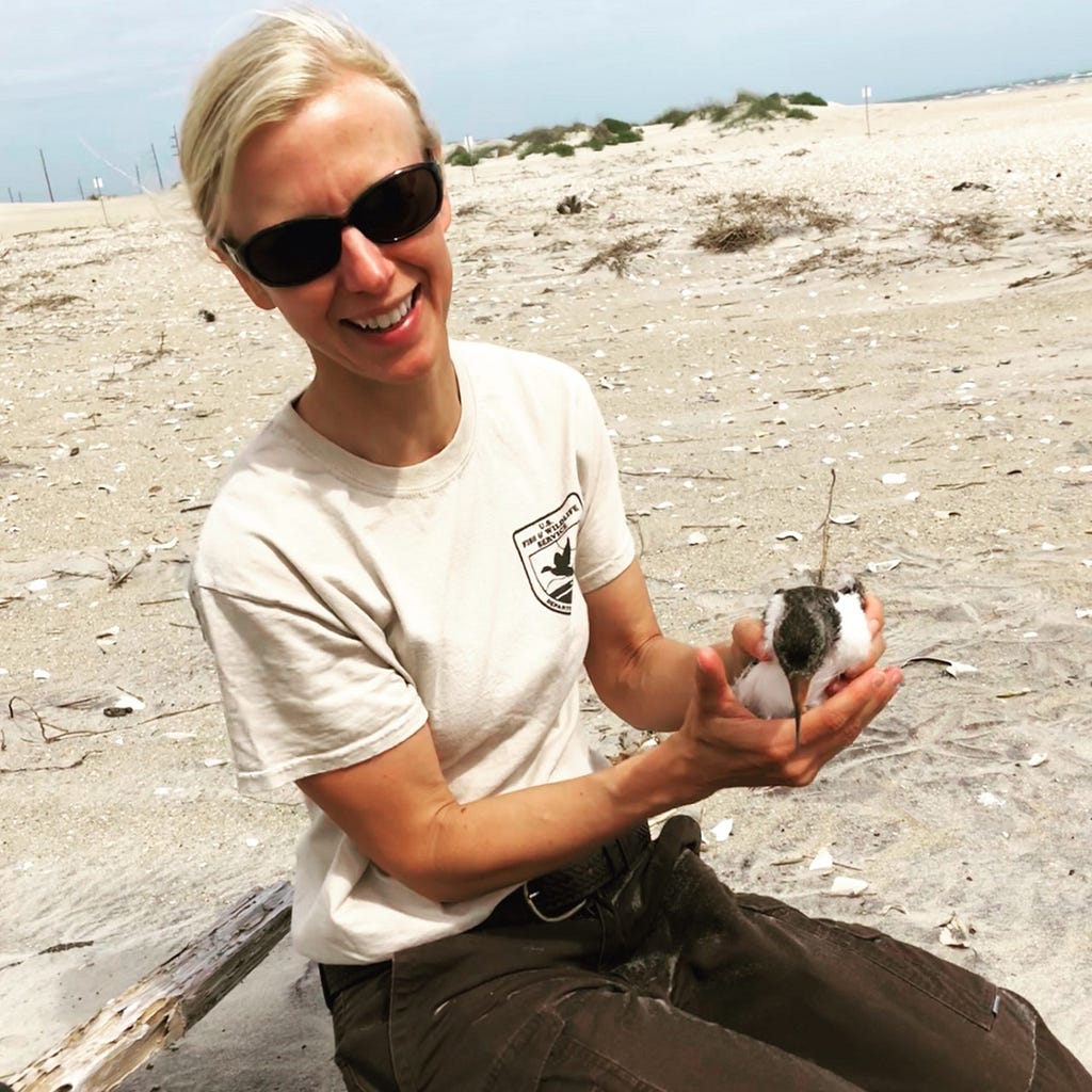 Becky Harrison, FWS Behind the Lens Photographer and Supervisory Biologist at the Coastal NC Wildlife Refuge Complex holding an American Oystercatcher