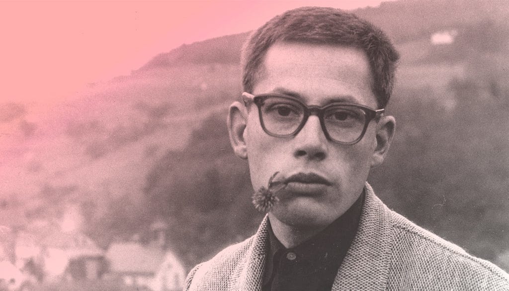 A portrait of Dieter Rams with a flower in his mouth