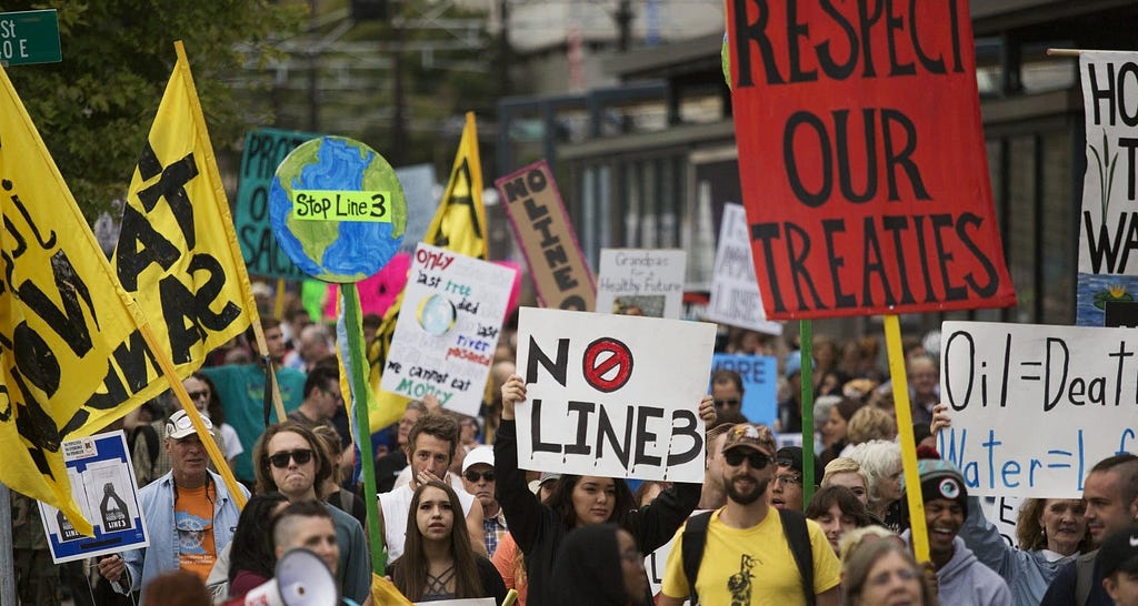 Protestors hold signs that say “No Line 3” and “Respect our Treaties” in St. Paul, MN, 2017