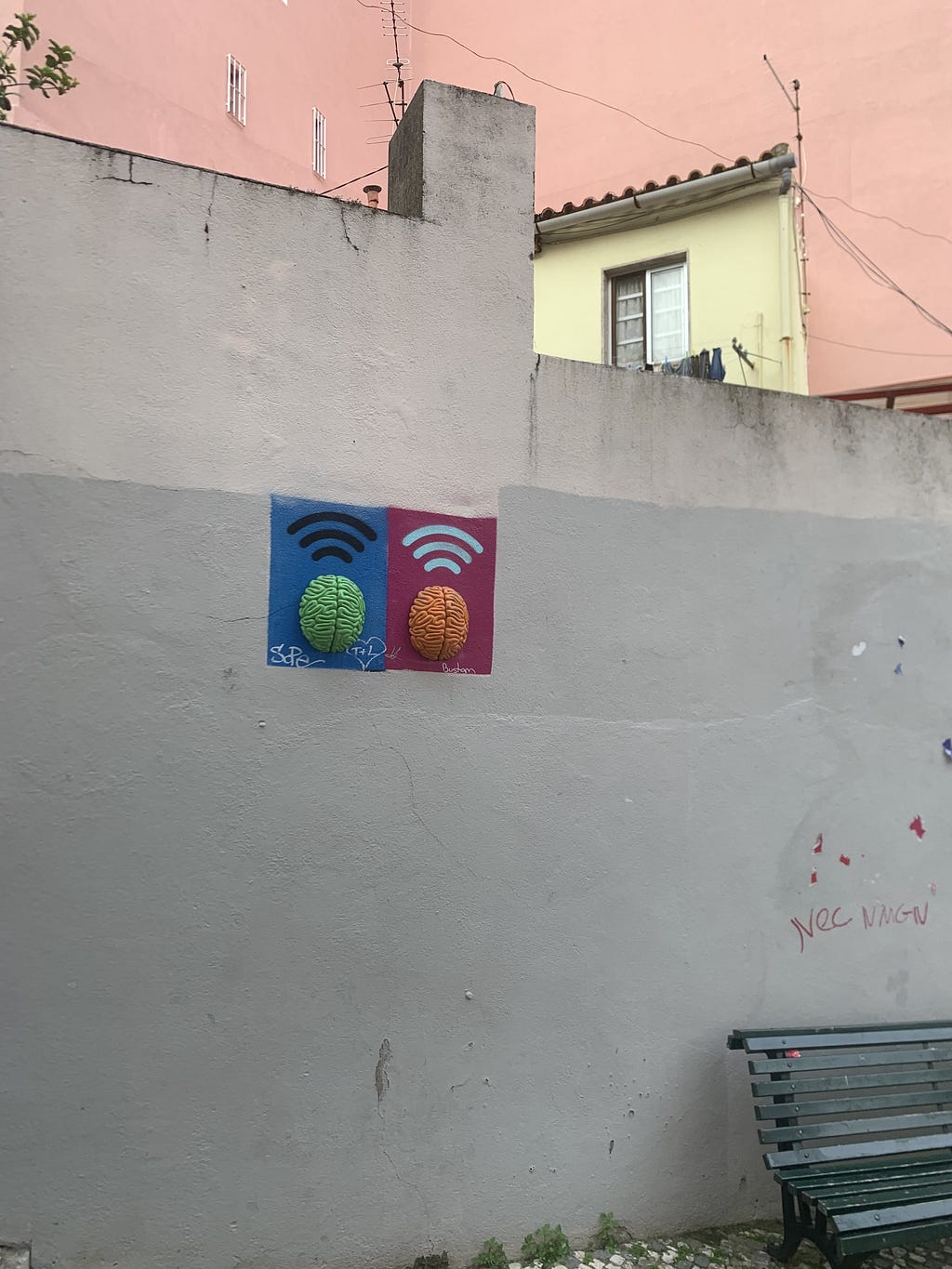 Weird art on the wall: two colorful brains with WIFI signal painted above.