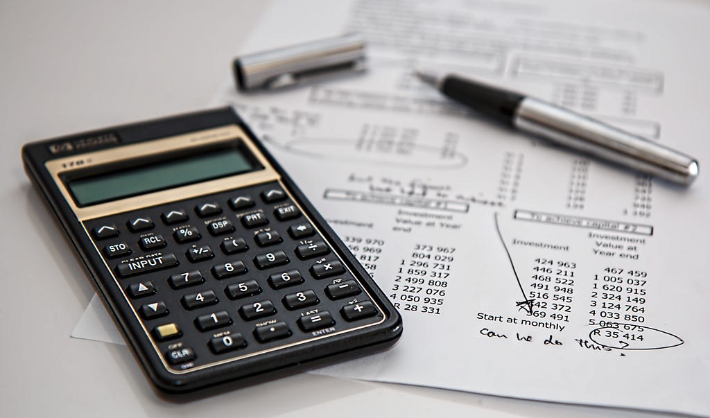 A calculator with a budgeting paper next to it