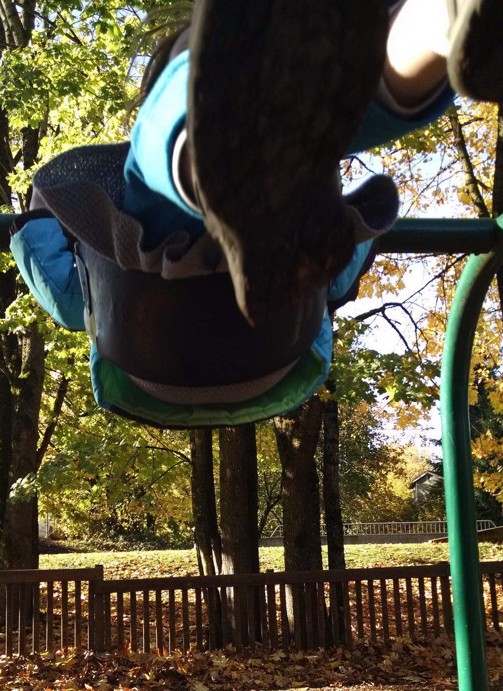 Person on park swing, feet and lower half of body mid-upward move