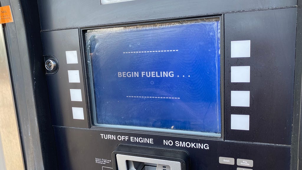 The blue payment screen at a gas pump that instructs you to begin fueling.