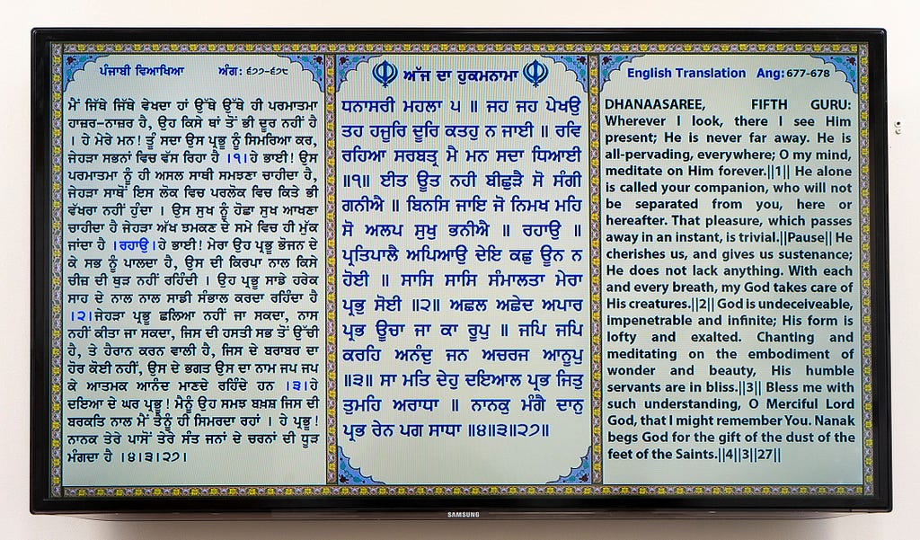 A triple panel — with two panels written in Punjabi and the third in English — holy scripture inside the Sikh Temple