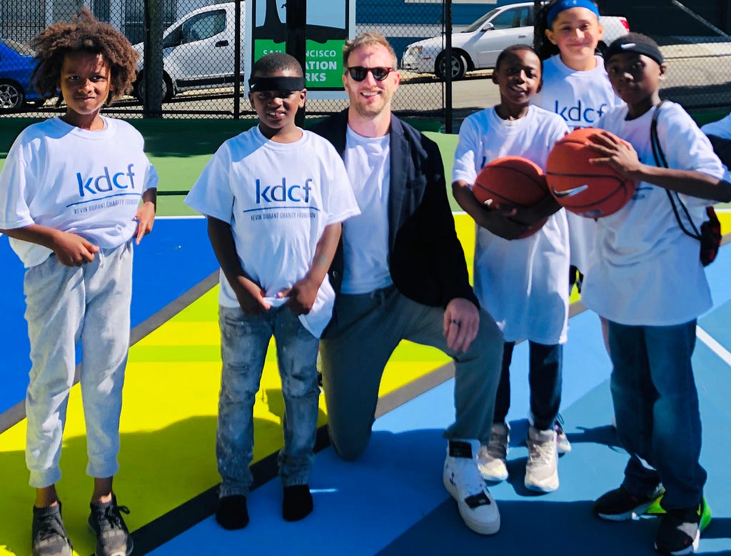 Joe with local youth basketball players at the court opening.