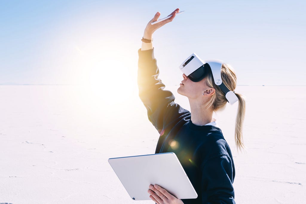 Industry worker or an engineer working with a tablet and a VR headset.