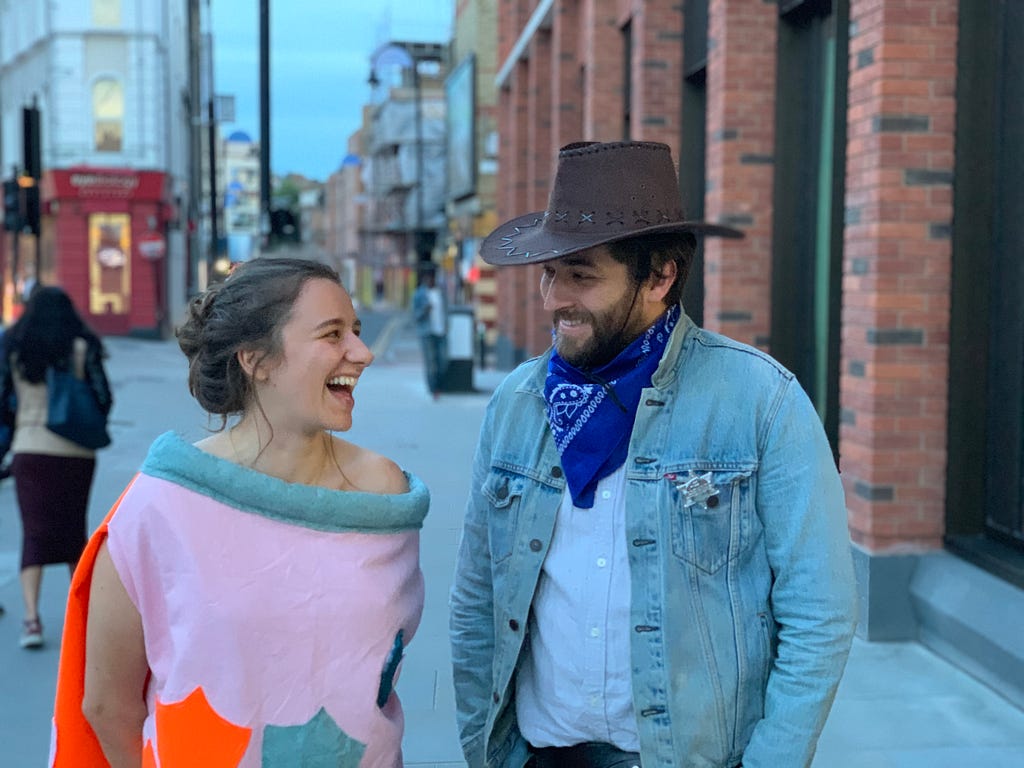 The author and his girlfriend smiling at each other in fancy dress. She is dressed as a fish, he is dressed as a cowboy.