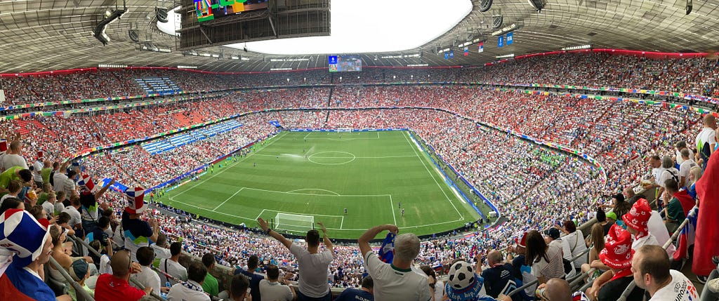 Fotografija nabito polnega stadiona Alianz Arena v Münchnu na tekmi EURO 2024, ko sta se pomerili reprezentanci Slovenije in Srbije. Izid je bil neodločen.