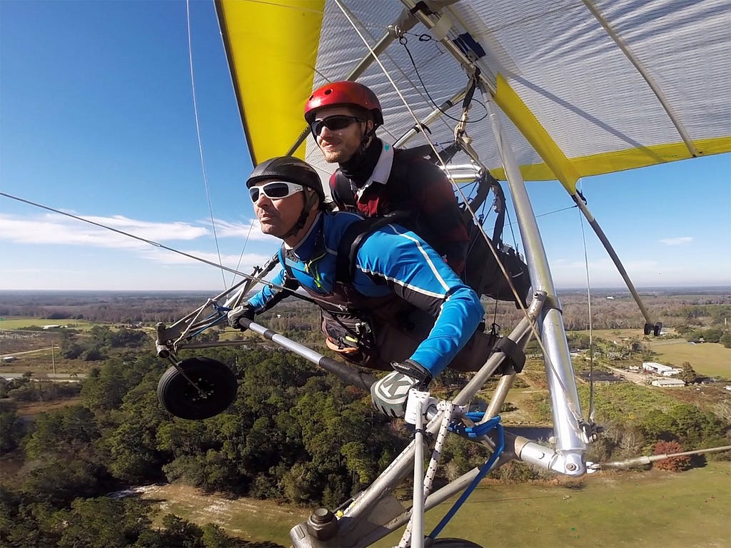 Two men flying in a hang glider above Lake County, Florida