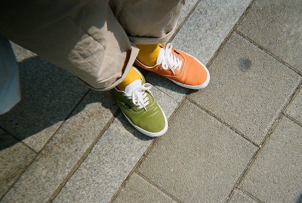 A pair of discolored shoes of orange and green can be seen.