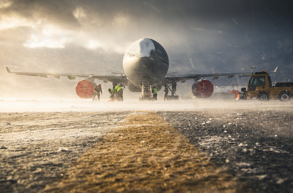 An RAF Voyager aircraft sits in the harsh winter weather at Mount Pleasant Complex, Falkland Islands while personnel work to