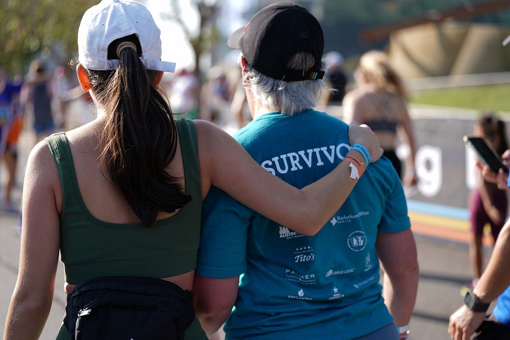 Woman with arm around cancer survivor at charity walk