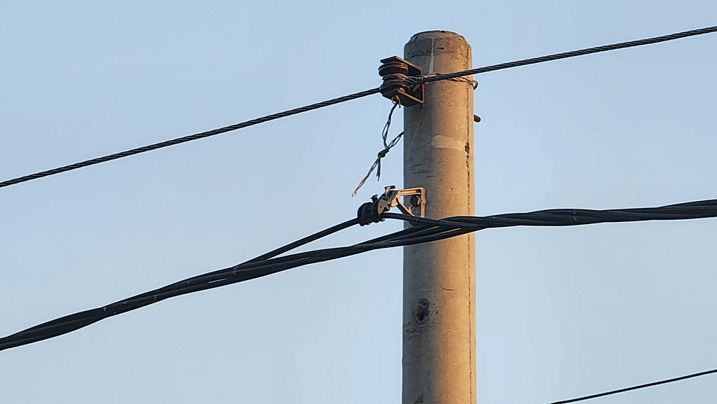 A utility pole with wires installed correctly and with safety in mind.