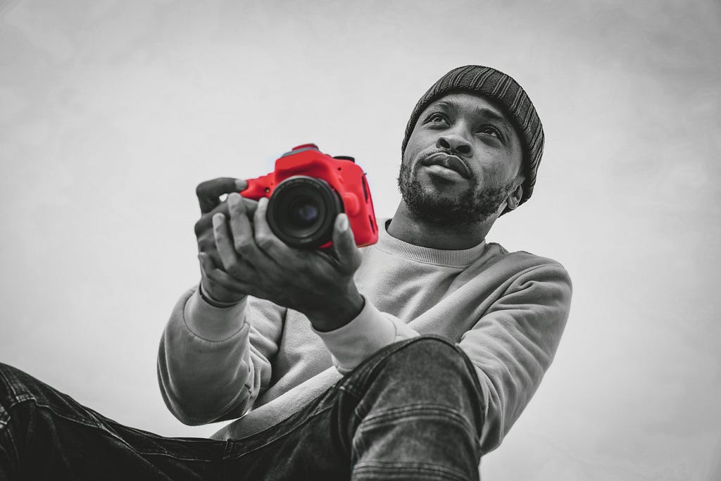 A photographer posing with his camera.