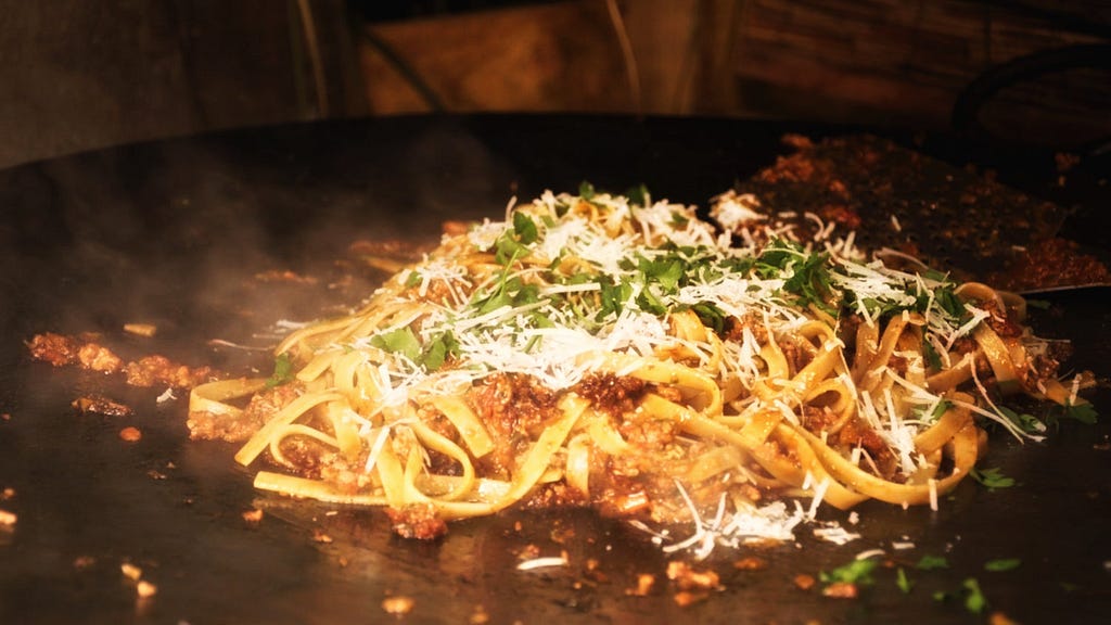Bolognese with homemade tagliatelle cooking on a tawa.