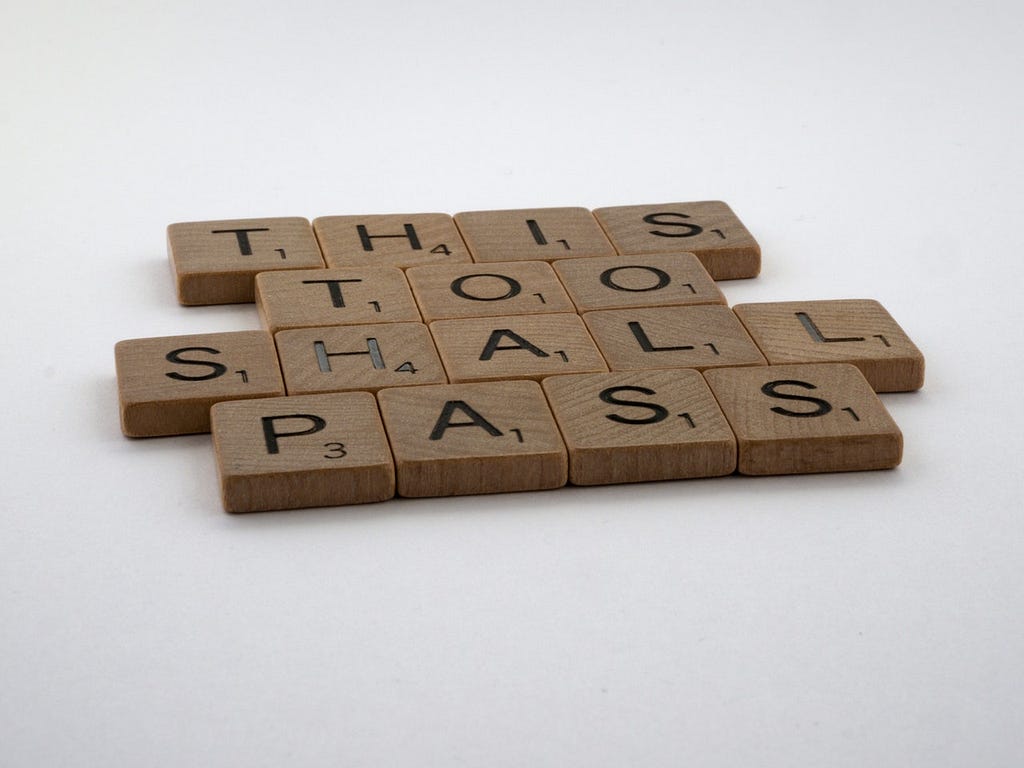 Scrabble blocks that spell out This Too Shall Pass