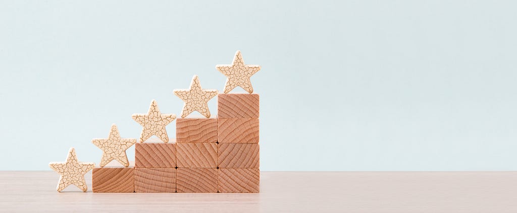 Picture of a stack of blocks forming a stair-step pattern, and on each of the four levels, there is a small wooden star.