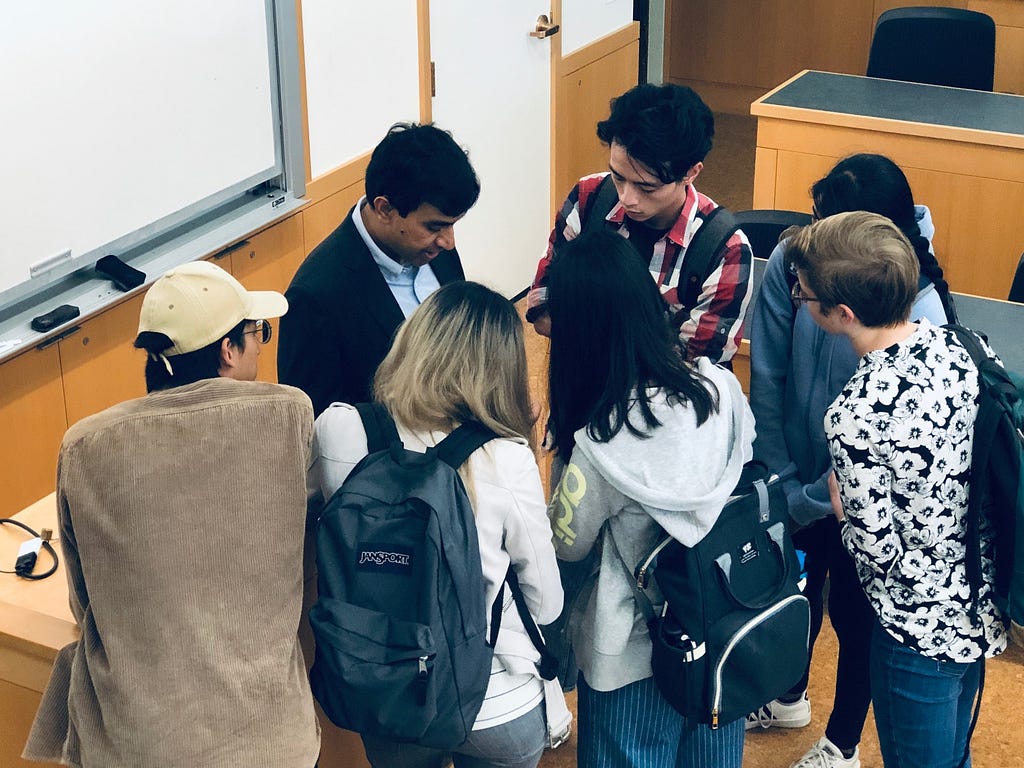 Atchin with a group of MEng students surrounding him in conversation.