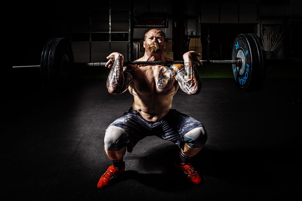 man-in-black-shorts-carrying-adjustable-barbells