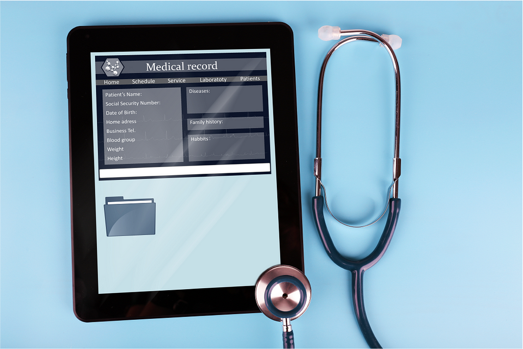 Stethoscope next to tablet showing healthcare app