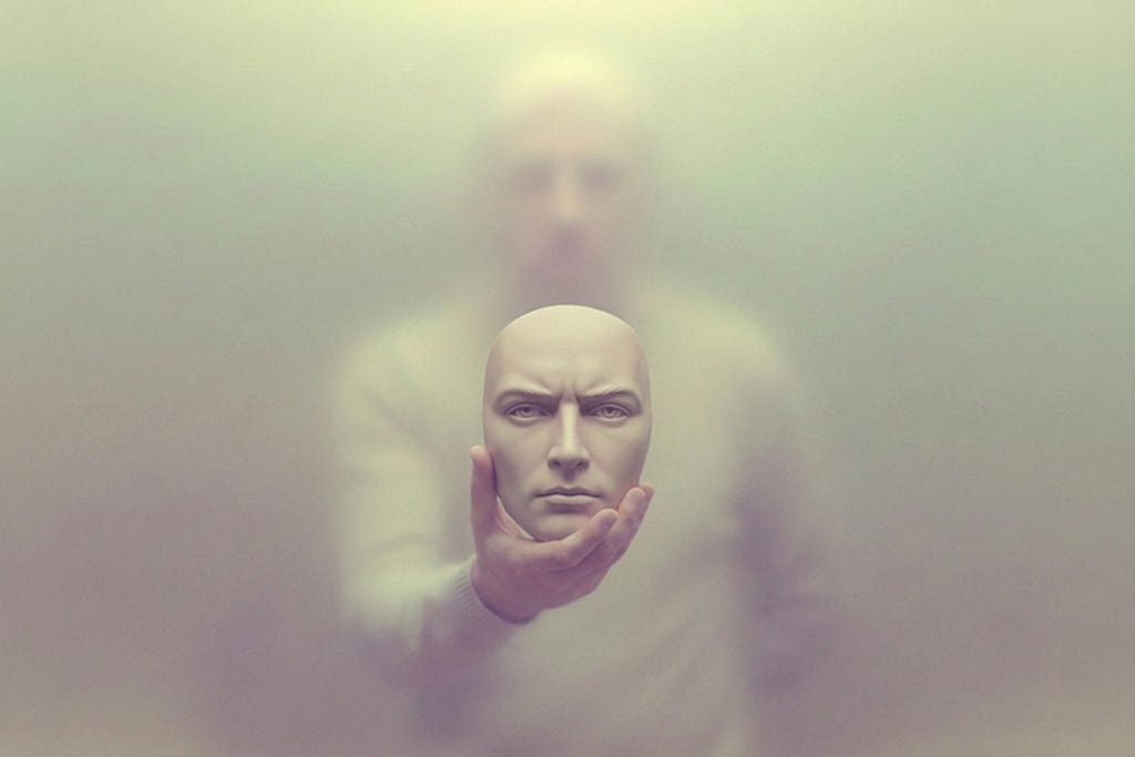A translucent mask held in hands with a blurred figure in the background, suggesting the separation between performance and identity.