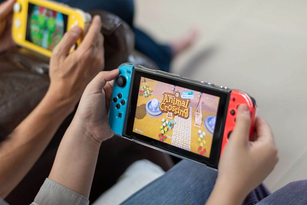 Two people playing games on a Nintendo switch showcasing its energy efficiency