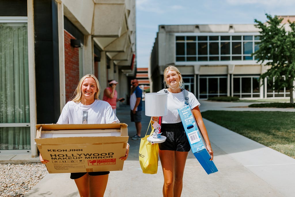 Avery Sindt, right, and her best friend, Skylar Gronewold, carry Sindt’s breakable possessions into Schramm Hall.