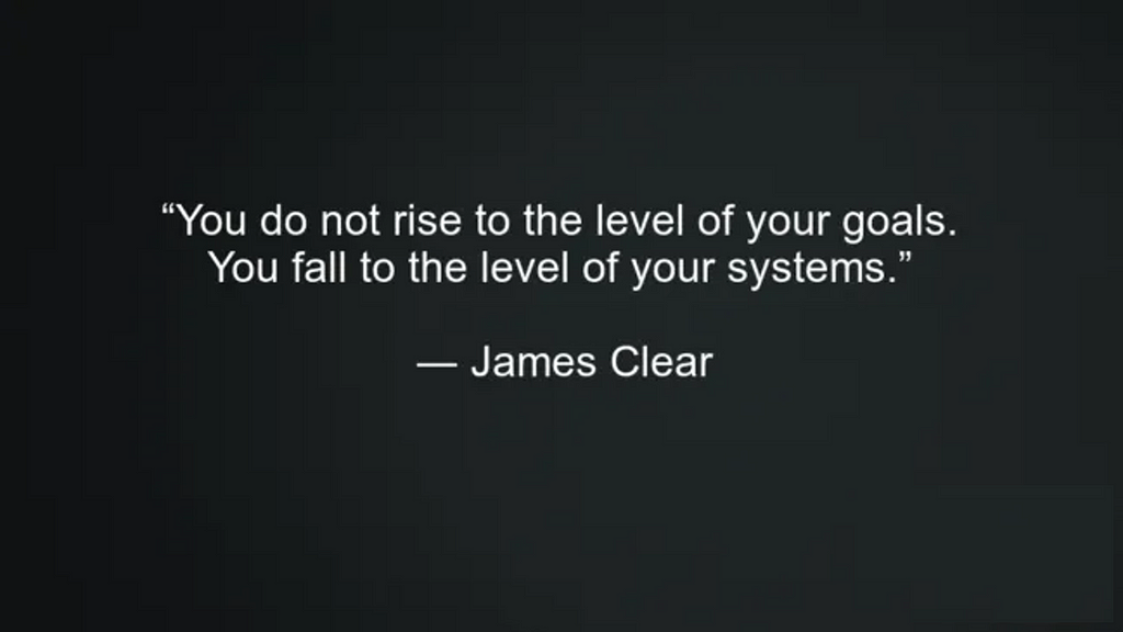 Text image: “You do not rise to the level of your goals. You fall to the level of your systems.” — James Clear