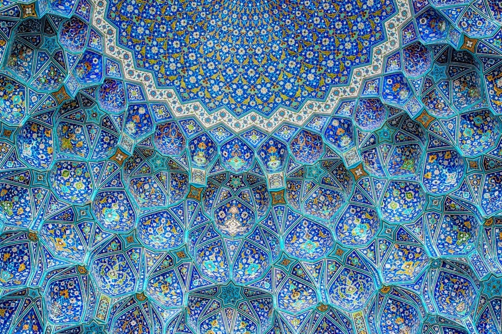 Ceiling and wall tile work in Shah Mosque in Naghshe-jahan Square, Isfahan, Iran. The mosque is also known as Jame’ Abbasi Mosque. It is one of the masterpieces of Iranian/Persian architecture and an excellent example of the architecture of Iran’s Islamic era and also one of the top tourist attractions in the country.