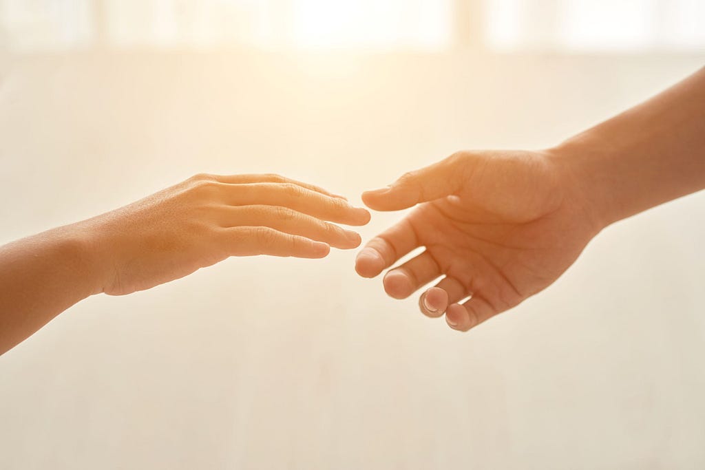 a photo of hands almost touching reflecting the verse love your neighbor